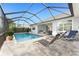Inviting screened-in pool area with comfortable lounge chairs and tiled patio at 16271 Branco Dr, Punta Gorda, FL 33955