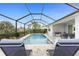 Inviting screened-in pool area with comfortable lounge chairs and tiled patio at 16271 Branco Dr, Punta Gorda, FL 33955