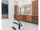 Elegant bathroom featuring dual sinks, wood cabinets, quartz countertop, stylish fixtures, and access to a closet at 1631 Casey Key Dr, Punta Gorda, FL 33950