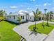 A stylish home with manicured landscaping and a curved paved driveway leading to a modern three-car garage at 1631 Casey Key Dr, Punta Gorda, FL 33950