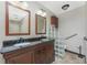 Bathroom featuring a double vanity with granite countertops and a glass block partition, and tiled flooring at 16571 Cape Horn Blvd, Punta Gorda, FL 33955