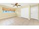 Neutral bedroom featuring tile flooring, a ceiling fan, a window with blinds, and a closet at 16571 Cape Horn Blvd, Punta Gorda, FL 33955