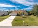 Well-manicured front lawn with long driveway leading to a charming single-story home at 16571 Cape Horn Blvd, Punta Gorda, FL 33955