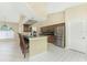 Open kitchen with a breakfast bar, stainless steel appliances, and wooden cabinets under high ceilings at 16571 Cape Horn Blvd, Punta Gorda, FL 33955