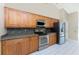 Modern kitchen with stainless steel appliances, granite counters, wood cabinets and ample counter space for cooking at 16571 Cape Horn Blvd, Punta Gorda, FL 33955