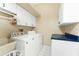 Functional laundry room equipped with a washer, dryer, white cabinets, and a utility sink at 16571 Cape Horn Blvd, Punta Gorda, FL 33955