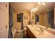 Bathroom featuring dual sinks, framed mirror, decorative fixtures, and a shower/tub combination at 17327 Wintergarden Ave, Port Charlotte, FL 33948