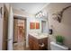 Bright bathroom with wooden vanity, sink, and tile flooring, and a glimpse of the kitchen beyond at 17327 Wintergarden Ave, Port Charlotte, FL 33948