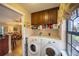 Well-equipped laundry room with modern washer and dryer units, cabinetry and adjacent to the living area at 17327 Wintergarden Ave, Port Charlotte, FL 33948