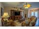 Comfortable living room featuring tile flooring, ceiling fan, and a media center for entertainment at 17327 Wintergarden Ave, Port Charlotte, FL 33948