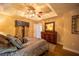 Comfortable main bedroom boasts stylish ceiling fan, tray ceiling, attractive decor, and warm lighting at 17327 Wintergarden Ave, Port Charlotte, FL 33948