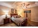 Comfortable main bedroom boasts stylish ceiling fan, tray ceiling, attractive decor, and warm lighting at 17327 Wintergarden Ave, Port Charlotte, FL 33948