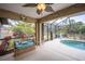 Screened outdoor pool area with ceiling fan and wicker love seat at 17327 Wintergarden Ave, Port Charlotte, FL 33948