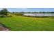 Lush green backyard with a serene lake view providing a peaceful and natural setting at 17954 Saddle Rd, Punta Gorda, FL 33982