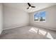 Bedroom featuring a ceiling fan, neutral carpet, and a view of the outdoors through a window at 17954 Saddle Rd, Punta Gorda, FL 33982