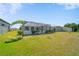 Spacious backyard with a screened-in pool area and lush green lawn at 18662 Arapahoe Cir, Port Charlotte, FL 33948