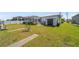 Spacious backyard features a screened enclosure, green grass, and a storage shed at 18662 Arapahoe Cir, Port Charlotte, FL 33948