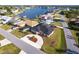 Aerial view of a lovely home with a spacious driveway, well-manicured lawn, and a serene lake in the background at 20339 Gentry Ave, Port Charlotte, FL 33952