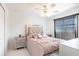 This bedroom includes gray furniture, a ceiling fan, and a window with blinds at 20339 Gentry Ave, Port Charlotte, FL 33952