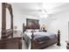 A primary bedroom with ornate dark wood furniture, a ceiling fan, and white walls at 20339 Gentry Ave, Port Charlotte, FL 33952
