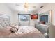 This bedroom includes gray furniture, a flatscreen tv, and a window with blinds at 20339 Gentry Ave, Port Charlotte, FL 33952