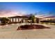 Charming single-level home with a circular driveway, lush landscaping, and inviting exterior illuminated at dusk at 20339 Gentry Ave, Port Charlotte, FL 33952