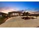 Elegant home with a spacious circular driveway, enhanced landscaping, and exterior lighting at twilight at 20339 Gentry Ave, Port Charlotte, FL 33952