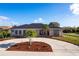 Charming single-story home featuring a circular driveway, lush landscaping, and a stone facade at 20339 Gentry Ave, Port Charlotte, FL 33952