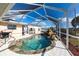 A caged pool with a small waterfall feature and an outdoor cooking area at 20339 Gentry Ave, Port Charlotte, FL 33952
