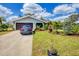 Single-story home boasting a well-maintained lawn with garden, a two-car garage, and a paved driveway at 2082 Broad Ranch Dr, Port Charlotte, FL 33948