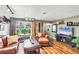 Inviting living room featuring hardwood floors, a leather sofa and chair, a large window and neutral decor at 2082 Broad Ranch Dr, Port Charlotte, FL 33948