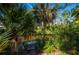 Private dock along lush canal surrounded by tropical foliage and mature palm trees at 2091 Cannolot Blvd, Port Charlotte, FL 33948