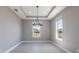 Bright dining room with a modern chandelier, tray ceilings, and plenty of natural light at 24473 San Rafael Rd, Punta Gorda, FL 33955