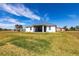 Rear view of a beautiful home with lush green lawn and screened-in lanai for relaxation at 24473 San Rafael Rd, Punta Gorda, FL 33955