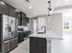 Modern kitchen with stainless appliances, a center island with sink, and dark cabinetry at 24473 San Rafael Rd, Punta Gorda, FL 33955
