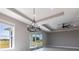 Spacious and bright living room featuring tray ceilings, modern fixtures, and large glass doors at 24473 San Rafael Rd, Punta Gorda, FL 33955