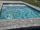 Backyard swimming pool surrounded by grey brick pavers at 24473 San Rafael Rd, Punta Gorda, FL 33955