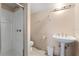 Clean, well-lit bathroom featuring a shower, toilet, pedestal sink, and modern fixtures at 250 George Rd, Port Charlotte, FL 33952