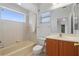Cozy bathroom featuring a window above the tub and a wood vanity cabinet at 250 George Rd, Port Charlotte, FL 33952