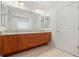 Bathroom features a wooden dual sink vanity with granite counters, a large mirror, and tile flooring at 250 George Rd, Port Charlotte, FL 33952