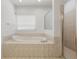 Bright bathroom features a large soaking tub with tile surround and a separate tiled shower at 250 George Rd, Port Charlotte, FL 33952