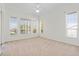 Bright bedroom featuring carpet, white walls, trim, and three large windows providing ample natural light at 250 George Rd, Port Charlotte, FL 33952