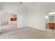 Open bedroom with neutral carpet leading to an en-suite bathroom and kitchen area at 250 George Rd, Port Charlotte, FL 33952