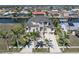 Aerial view of home with water views, lush landscaping, metal roof, and a large concrete driveway in a waterfront community at 250 George Rd, Port Charlotte, FL 33952