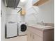 Convenient laundry room with washer, dryer, utility sink, and storage shelves at 250 George Rd, Port Charlotte, FL 33952