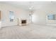Bright living room featuring a fireplace, neutral carpet and a ceiling fan for added comfort at 250 George Rd, Port Charlotte, FL 33952