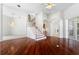 Living room with hardwood floors, staircase, and an archway to a room with a fireplace at 250 George Rd, Port Charlotte, FL 33952
