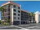 Exterior view of a multi-story condo building with covered parking and well-maintained grounds at 25188 Marion Ave # F303, Punta Gorda, FL 33950