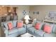Comfortable living room with sofas, decorative pillows, and bar seating open to the adjacent kitchen and dining area at 25188 Marion Ave # F303, Punta Gorda, FL 33950