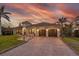 A charming two-story home features lush landscaping, and a long paver driveway at 257 Lido Dr, Punta Gorda, FL 33950
